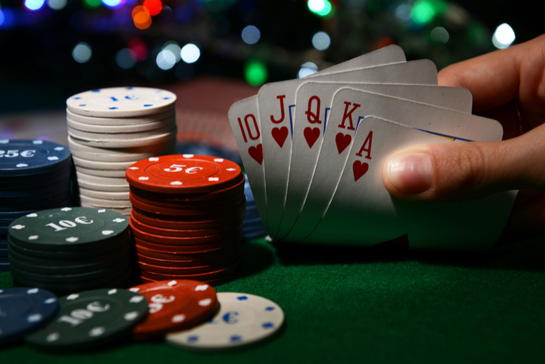 Chips and cards for poker in hand on green table