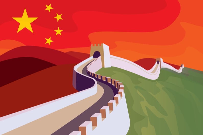 The great Wall of China with Chinese flag in the sky