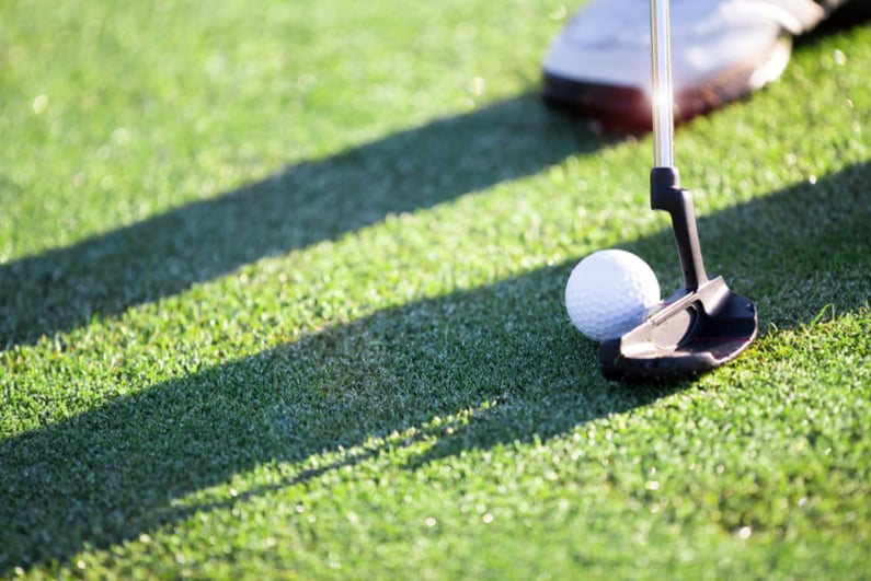 Golfer about to strike putt