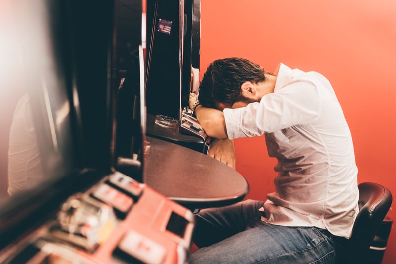 Despondent man at slot machine