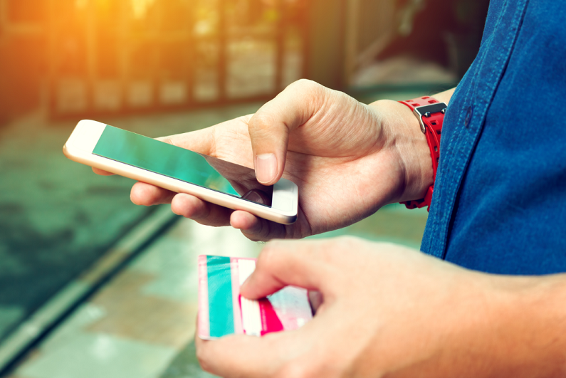 man-using-smartphone-and-holding-credit-card