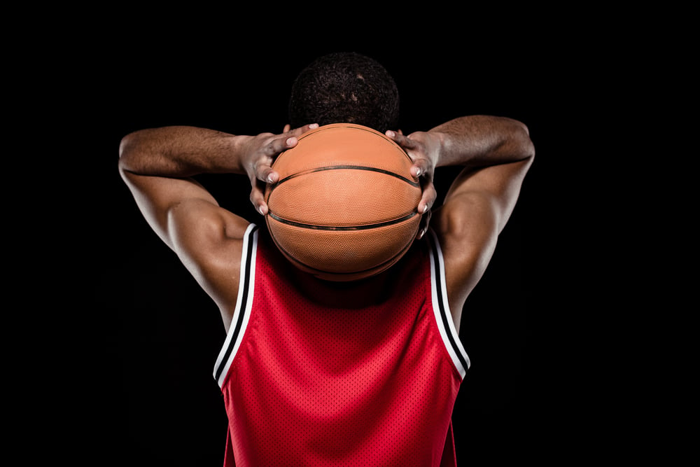 black-man-holding-basketball-behind-his-head