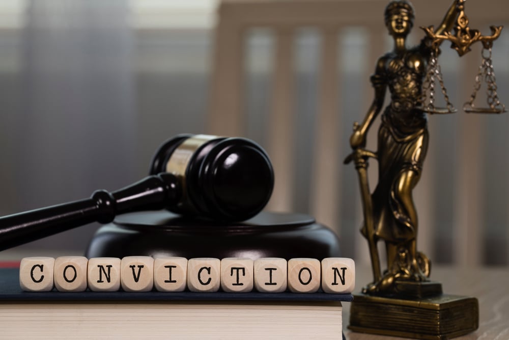 "CONVICTION" spelled out with dice, with judge's gavel and statue of Themis