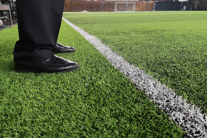 coach standing at side of pitch