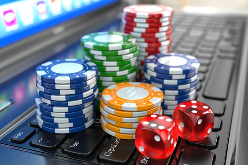 Casino chips and red dice on laptop keyboard