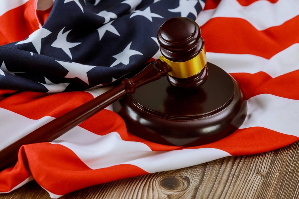 A judge's gavel resting on the US flag