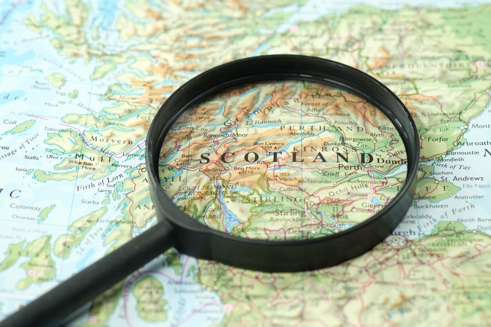 magnifying glass focuses on map of Scotland