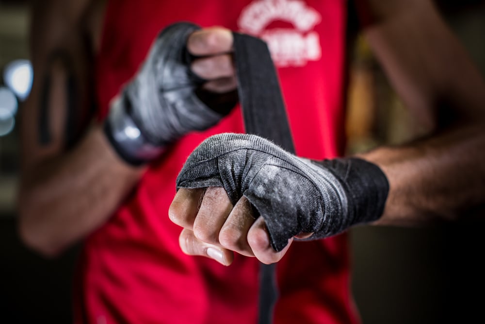 boxer wrapping up his hands with black fabric