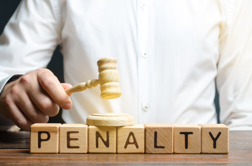 letter cubes spell out penalty as hand holds a judge's gavel