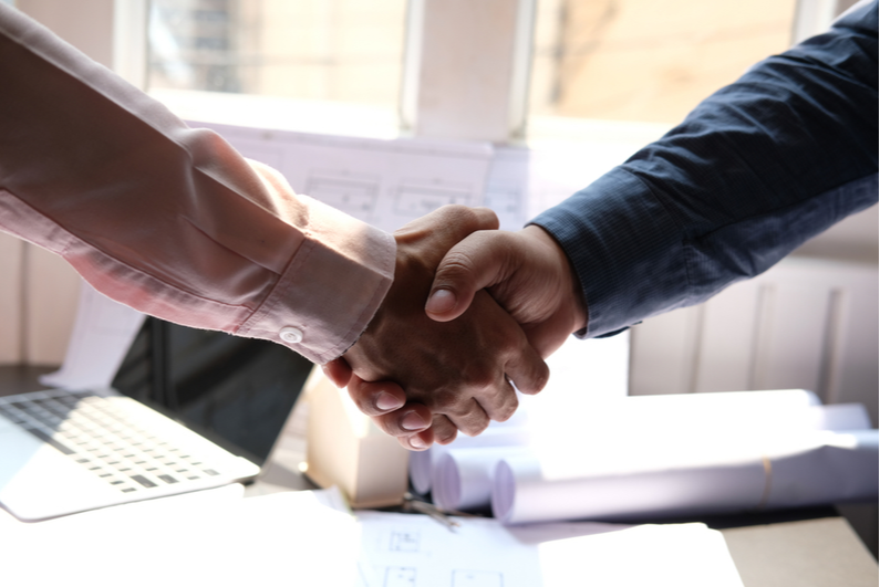 Two men shaking hands over a construction deal